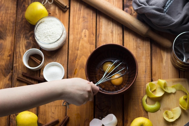 Ręka trzymająca łyżkę nad garnkiem